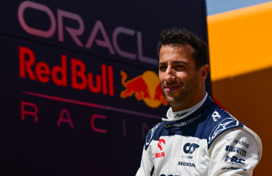 F1 driver Daniel Ricciardo in front of a redbull racing sign